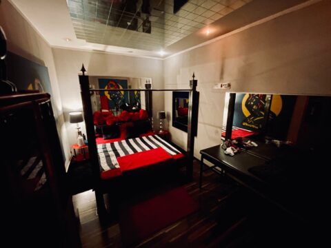 Ein schwarz-rotes Schlafzimmer mit einem Himmelbett.