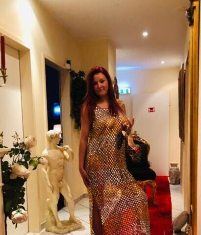 Eine Frau in einem Kleid mit Leopardenmuster steht auf einem roten Teppich.