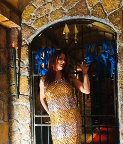 Eine Frau in einem Kleid steht vor einer Tür.